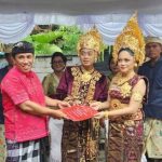 Perbekel Desa Gadungan, I Wayan Muliartana, menyerahkan akta perkawinan kepada pasangan pengantin dalam program Semara Ratih di Desa Gadungan, Kecamatan Selemadeg Timur, Tabanan, Senin (25/8/2025). (Foto: Istimewa)