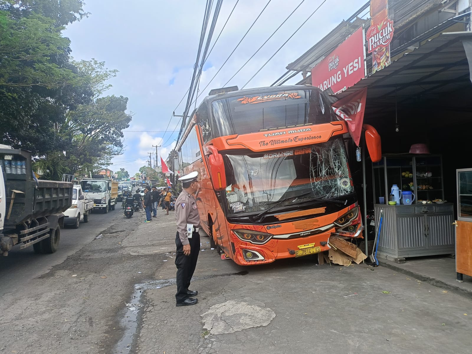 Sebuah bus Hino bernomor polisi E-7614-KB menabrak warung di pinggir Jalan Nasional Denpasar–Gilimanuk, Desa Bantas, Selemadeg Timur, Tabanan, Bali, akibat rem blong, Minggu (3/8/2025). Tidak ada korban jiwa dalam kejadian tersebut. (Foto: Istimewa)