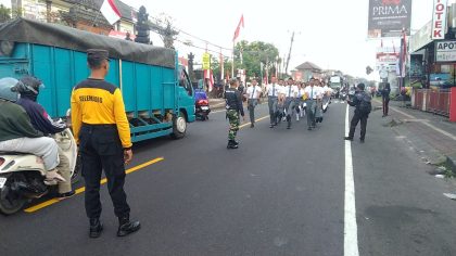 "Anggota Paskibra Kecamatan Selemadeg melaksanakan latihan baris-berbaris di jalan raya menjelang HUT ke-80 RI, dengan pengawalan aparat keamanan." (Foto: Humas Polsek Selemadeg)