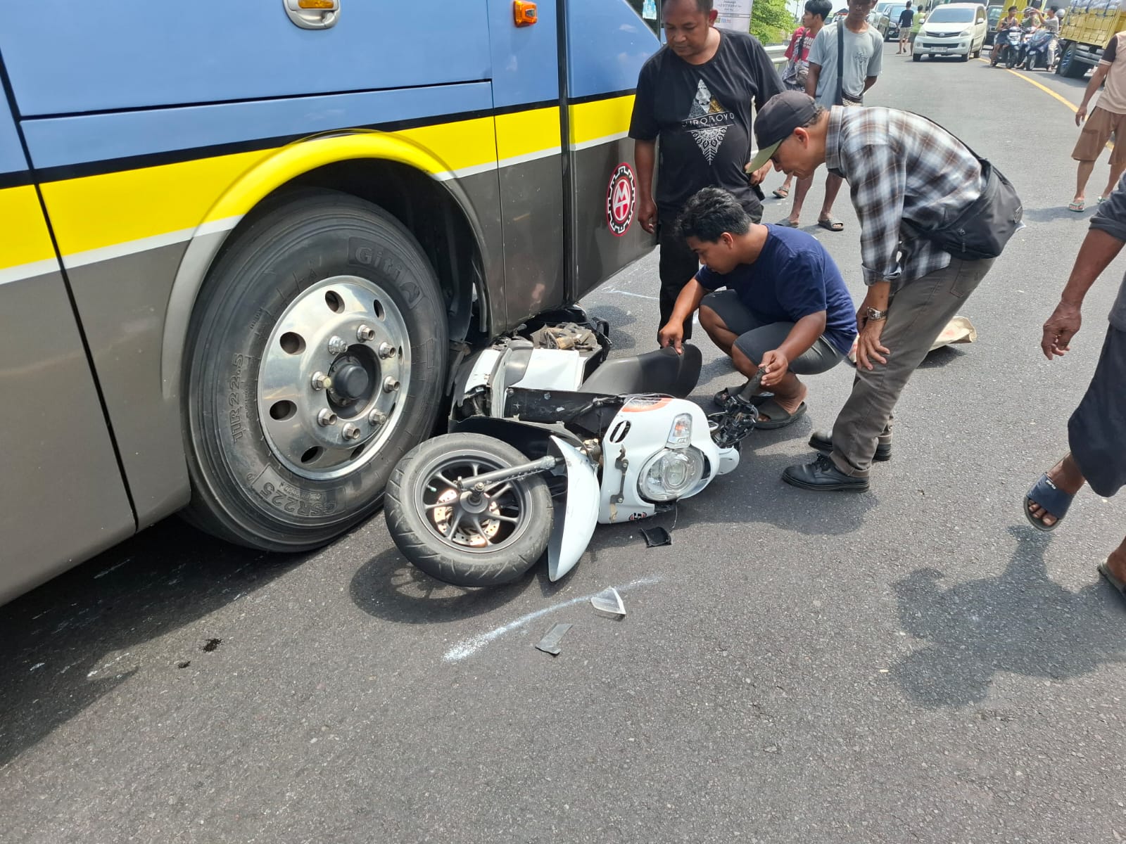 “Warga bersama petugas mengevakuasi sepeda motor Honda Scoopy yang ringsek setelah terlibat tabrakan dengan bus di jalur utama Denpasar–Gilimanuk, tepatnya di wilayah Desa Bajera, Selemadeg, Tabanan, Minggu (24/8/2025).” (Foto: Istimewa)