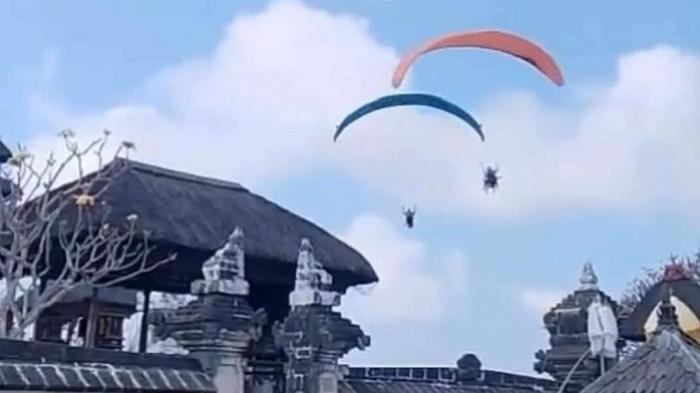 Dua paralayang melintas di atas kawasan suci Pura Gunung Payung, Desa Kutuh, Kuta Selatan, Badung, Bali, yang memicu kecaman masyarakat dan tokoh publik, Minggu (3/8/2025). (Foto: Istimewa)