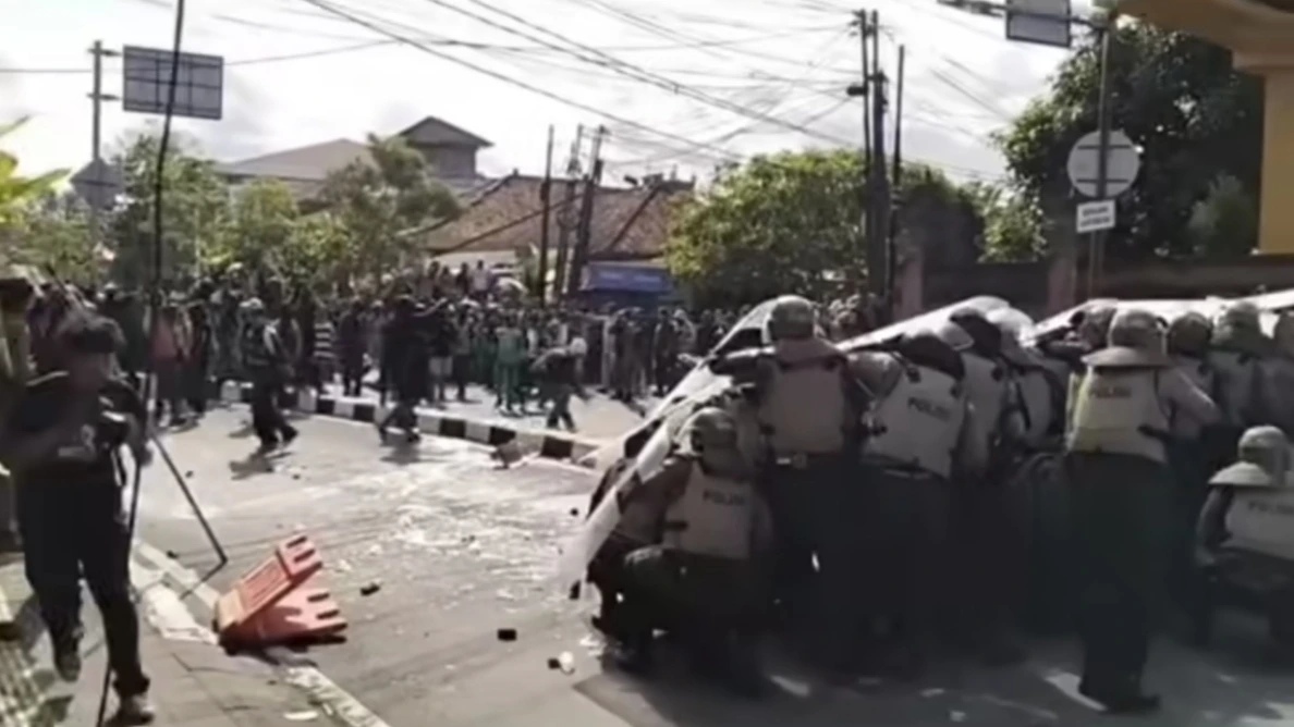 Aparat kepolisian membentuk barikade dengan tameng saat menghadapi lemparan massa dalam aksi unjuk rasa di depan Kantor DPRD Bali, Sabtu (30/8/2025). Kericuhan sempat pecah hingga nyaris membakar kendaraan milik aparat. (Foto: Istimewa)