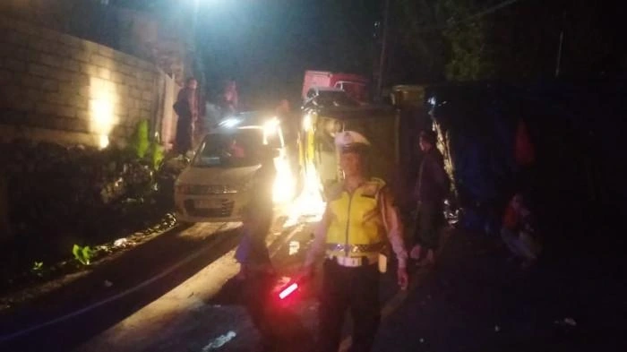 Petugas kepolisian mengatur lalu lintas di lokasi kecelakaan tunggal truk bermuatan ijuk yang terguling di tanjakan Desa Gitgit, Sukasada, Buleleng, Rabu malam (6/8/2025). (Foto: Istimewa)