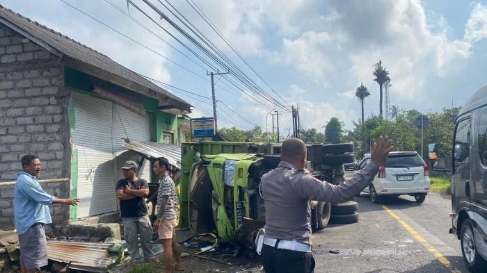 Petugas kepolisian melakukan pengaturan lalu lintas usai sebuah truk terguling dan menabrak warung warga di Banjar Dinas Nongan Kaler, Desa Nongan, Kecamatan Rendang, Karangasem, Rabu (3/9/2025). Tidak ada korban jiwa dalam insiden tersebut. (Foto: Istimewa)