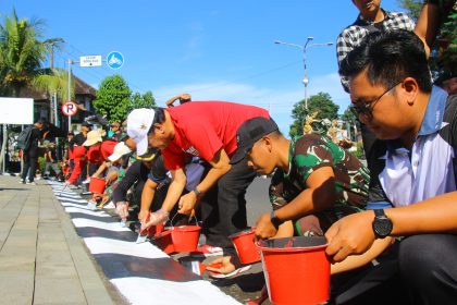 Pegawai Pemkab Tabanan bersama jajaran Forkopimda bergotong royong melakukan pengecatan trotoar di kawasan pusat Kota Singasana dalam rangka menyambut HUT ke-532 Kota Singasana. (Foto: Istimewa)