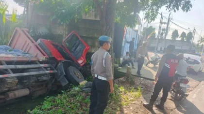 Petugas kepolisian bersama warga mengevakuasi truk bermuatan semen yang terperosok di pinggir Jalan Raya Denpasar–Gilimanuk, Desa Pangyangan, Pekutatan, Jembrana, Minggu (2/11/2025). (Foto: Istimewa)