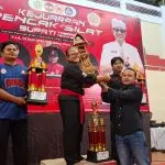 Penyerahan piala kepada perwakilan SMKN 2 Tabanan usai dinobatkan sebagai Juara Umum I tingkat SMA pada Kejuaraan Silat Bupati Tabanan Cup 2026 di GOR Debes, Minggu (12/4). (Foto: Istimewa)